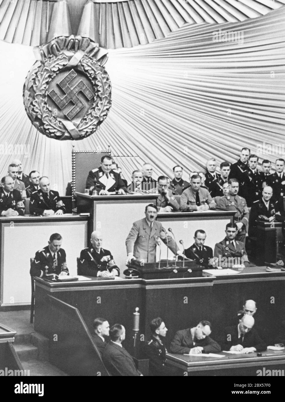 Session of the Reichstag in the Berlin Kroll Opera House on 18.03.1938 during the speech of Adolf Hitler. Behind Hitler at the desk of the Reichstag President, Hermann Goering. Sitting to his left, from left to right: Wilhelm Brueckner and Hans-Heinrich Lammers. Stock Photo