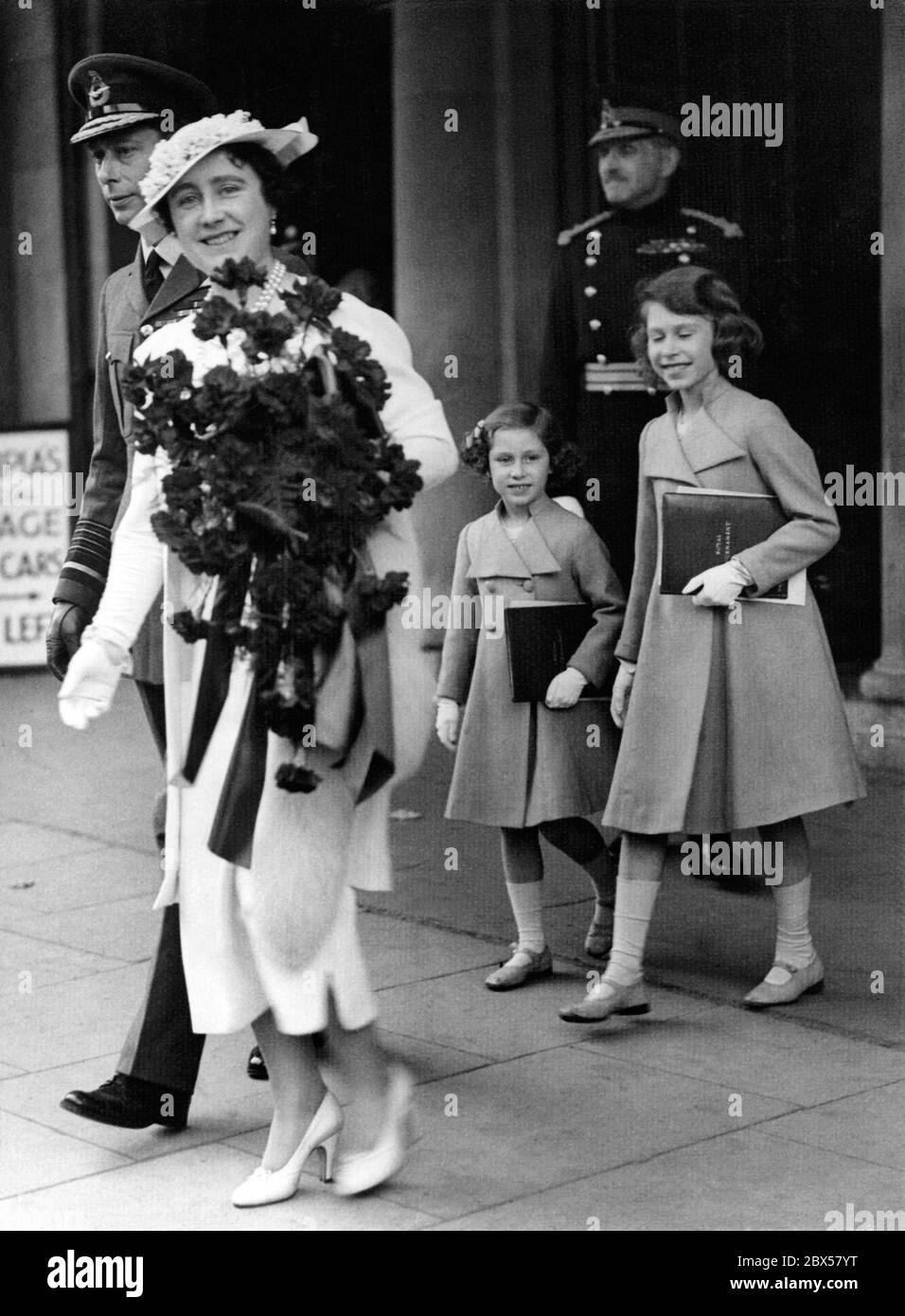 Elizabeth II (right) leaves the opening ceremony of the Coronation Royal Tournament in Olympia, London, accompanied by Queen Elizabeth (left) carrying a large bouquet of flowers, King George V and Princess Margaret Rose (centre). Stock Photo