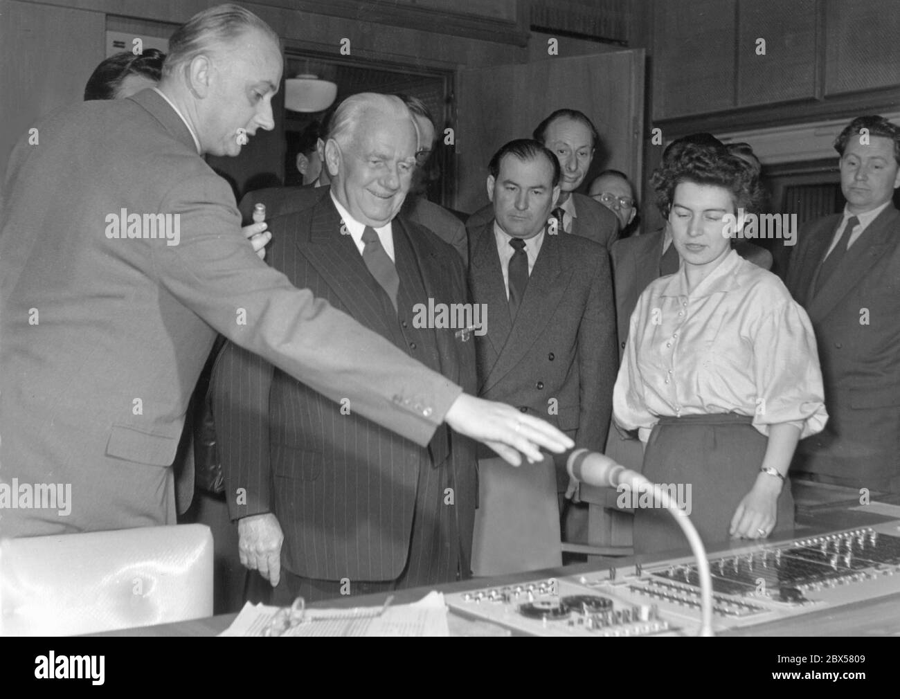 The President of the GDR, Wilhelm Pieck, visited the Rundfunk der DDR on May 27, 1956 in the Nalepastrasse in Berlin-Oberschoeneweide, where all radio programs of the GDR (Radio DDR, Stimme der DDR, Deutschlandsender, Berliner Rundfunk, Berliner Welle and the foreign radio station Radio Berlin International RBI) were produced until 1990. Pieck listens to the presentation of Gerhard Probst, Federal Deputy Minister of Post and Telecommunications responsible for broadcasting and television, in the control room of the technical equipment. Stock Photo