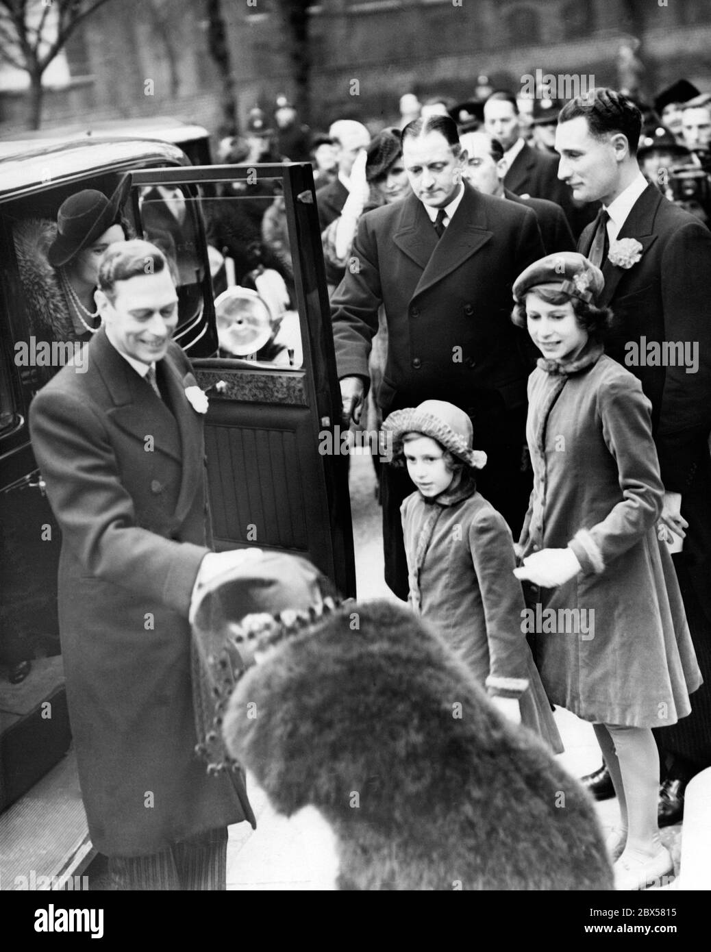 Elizabeth II (right) with her sister Princess Margaret Rose, King George VI (front) and Queen Elizabeth ( hidden) on their way to the wedding of Cecilia Bowes-Lyon, the eldest daughter of Lord Glamis Timothy Bowes-Lyon and Mr. Kenneth Harington at the Holy Trinity Church. Stock Photo