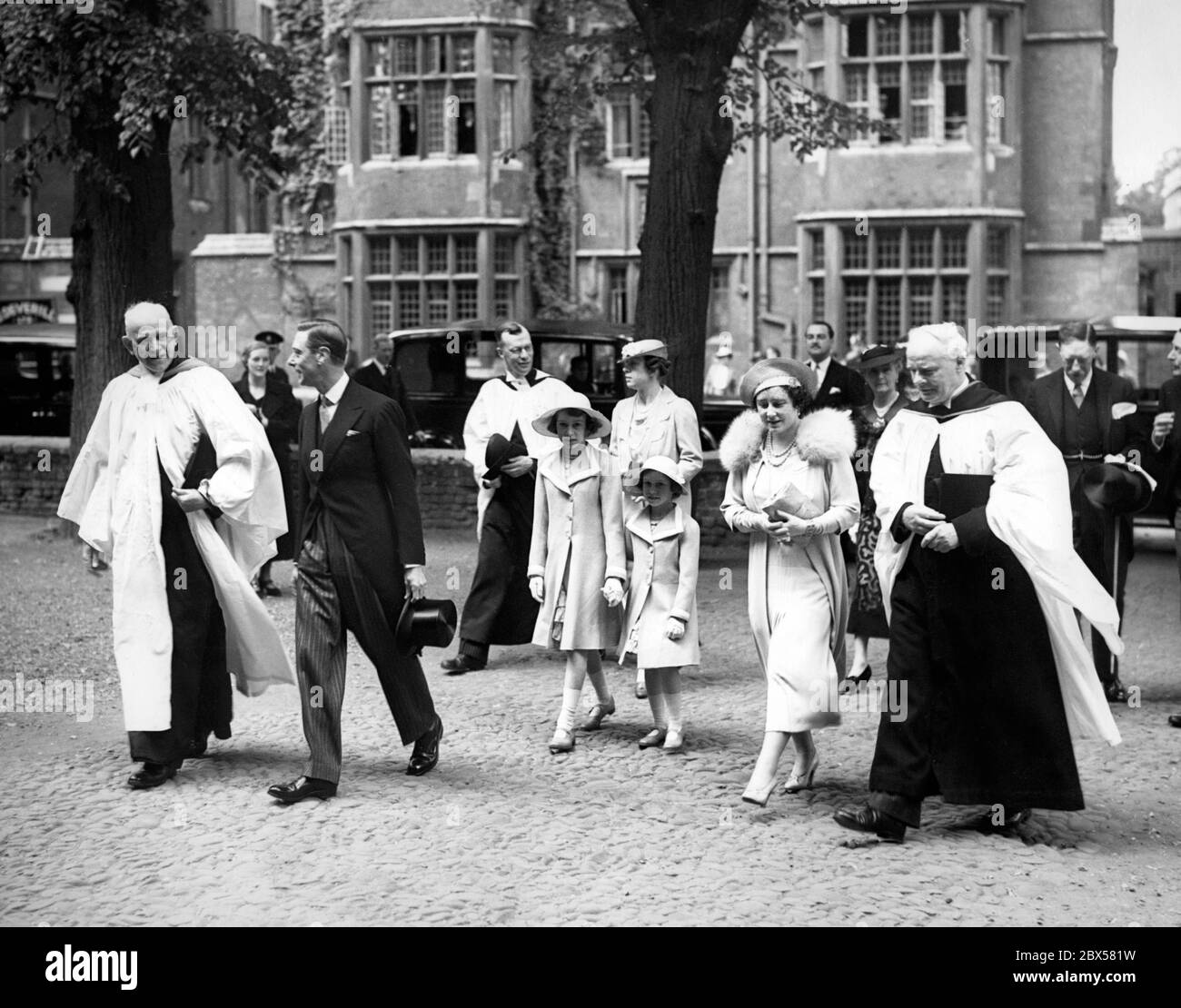 Provost Lord Hugh Cecil, King George VI, Princess Elizabeth and Princess Margaret Rose, Queen Elizabeth and Vice-Provost Mr. C.H.K. Marten on their arrival to the morning service at Eton College Chapel. In the background are the headmaster Mr. Claude Elliott and Princess Mary. Stock Photo