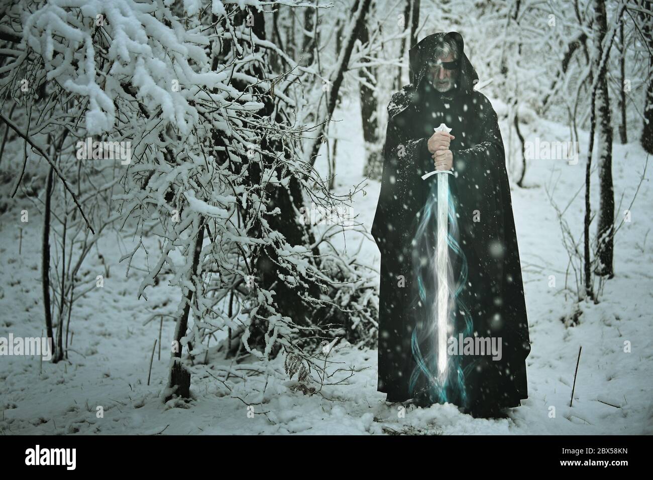 Mysterious old man with magical ice sword . Myth and fantasy Stock Photo