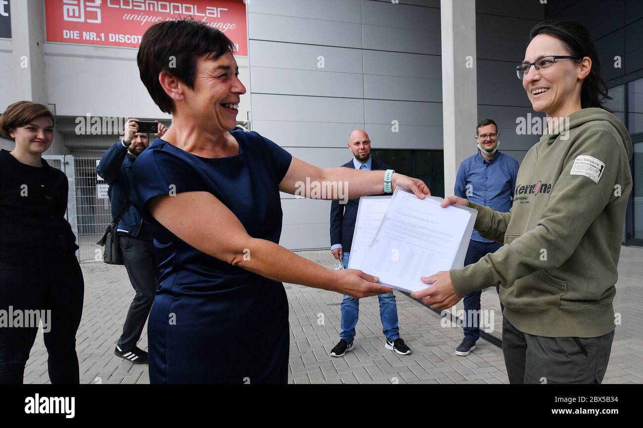 05 June 2020, Thuringia, Erfurt: Anja Müller (Die Linke, front l), Chairwoman of the Petitions Committee of the State Parliament, receives more than 10,450 signatures for the petition 'Against the shooting down of the 1st she-wolf of Thuringia' from Sabine Storch (r), initiator of the petition. The conservationists emphasize that not all alternatives to shooting down the Ohrdrufer wolf have been exhausted yet. The Ministry of the Environment had obtained a permit for the shooting from the highest nature conservation authority of the state. Photo: Martin Schutt/dpa-Zentralbild/dpa Stock Photo