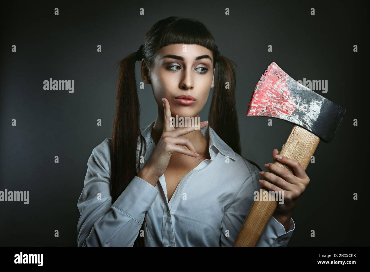 Dangerous woman with axe full of blood. Funny and amazed expression Stock Photo
