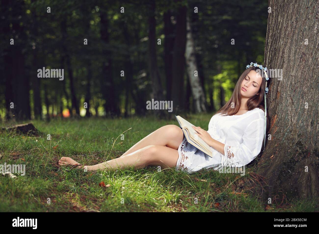 Beautiful woman dressed like a nymph sleeping peacefully in the forest Stock Photo