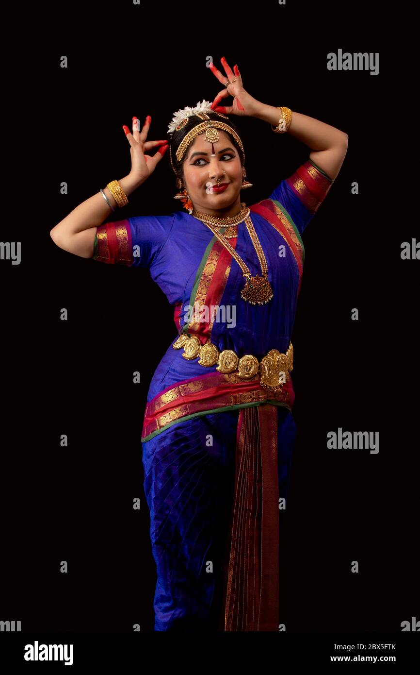 Bharatnatyam dancer performing in front of a dark background. Stock Photo