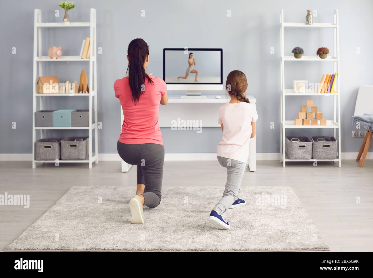 Fitness video course online. Family watching fitness training exercises online sports trainer course using video computer Stock Photo