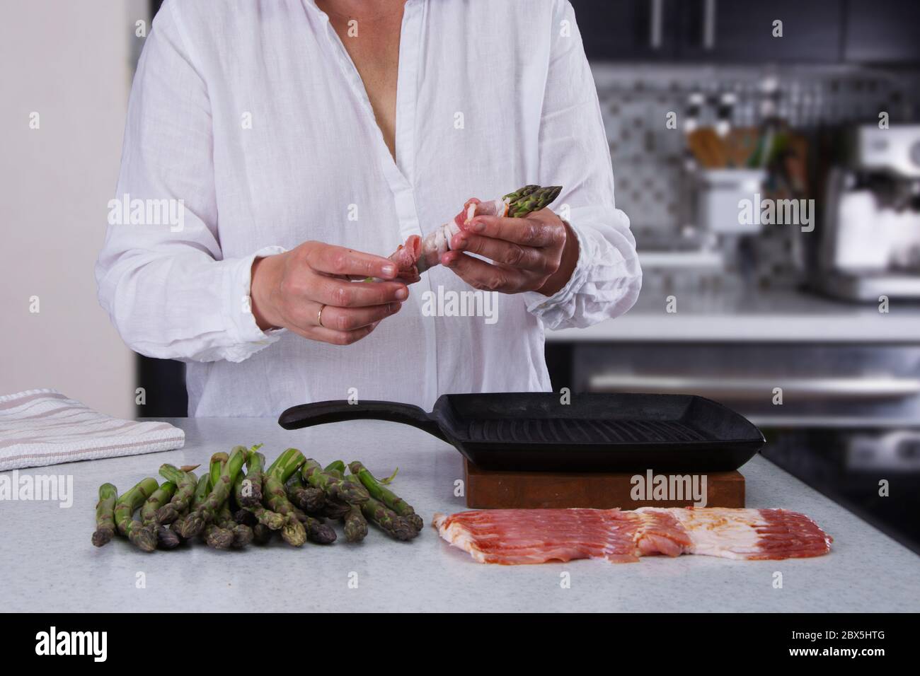 Woman in white linen shirt cooking fresh asparagus stock photo alamy