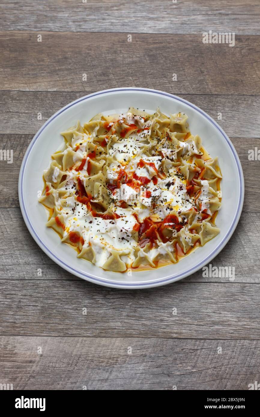 manti ( turkish ravioli type dumplings )served with garlic yoghurt, melted aleppo pepper butter and dry mint and sumac Stock Photo