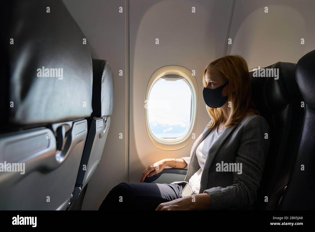 Woman wearing a face mask on a flight Stock Photo Alamy