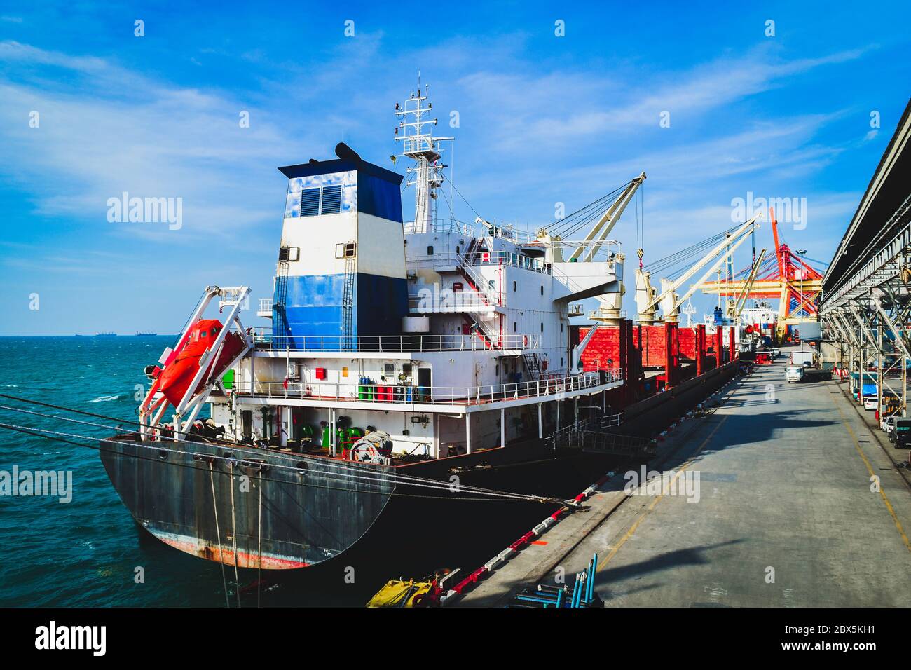 Large cargo ship loading and unloading cargo at the seaport Stock Photo ...