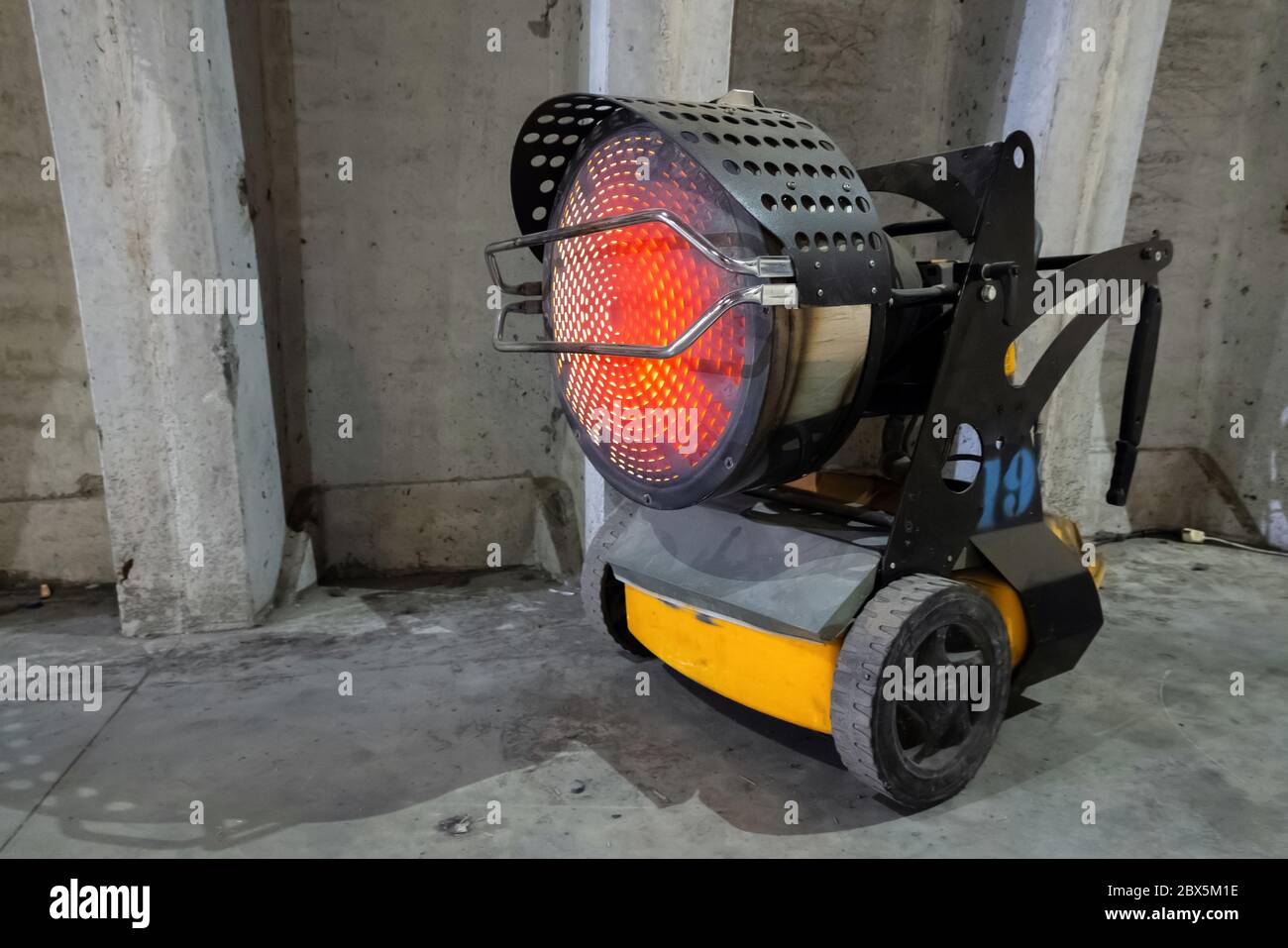 Heavy duty industrial heater blowing hot air in cold building interior