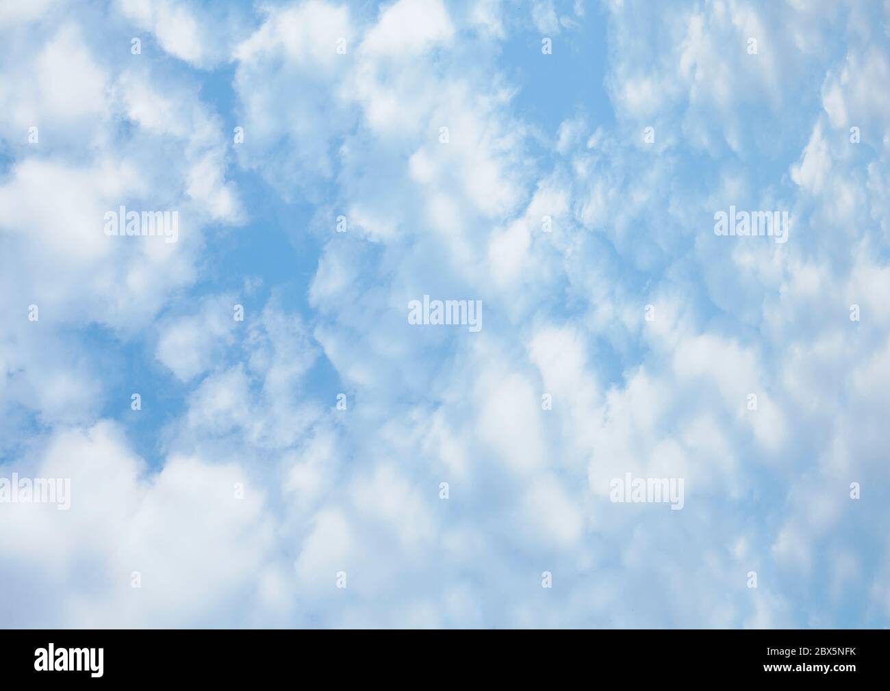 Pale blue sky with fluffy clouds backgground Stock Photo Alamy
