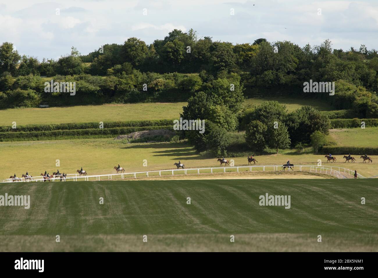 Kingsclere, Hampshire. 5th June, 2020. Riders and their horses train on the gallops, at the Kingsclere Park House Stables, which are run by horse racing trainer Andrew Balding, in Hampshire, Britain on June 5, 2020. Horse racing behind closed doors has resumed gradually in Britain after the government eased some lockdown restrictions. Racing is taking place behind closed doors with strict measures taken to prevent the spread of coronavirus. Credit: Tim Ireland/Xinhua/Alamy Live News Stock Photo