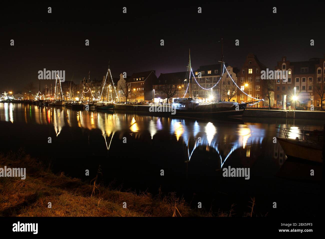 Luebeck, Germany - 2 Dezember 2016: View of Luebeck and the river Trave at night. Photo taken at 'An der Untertrave', ships decorated with lights. Stock Photo
