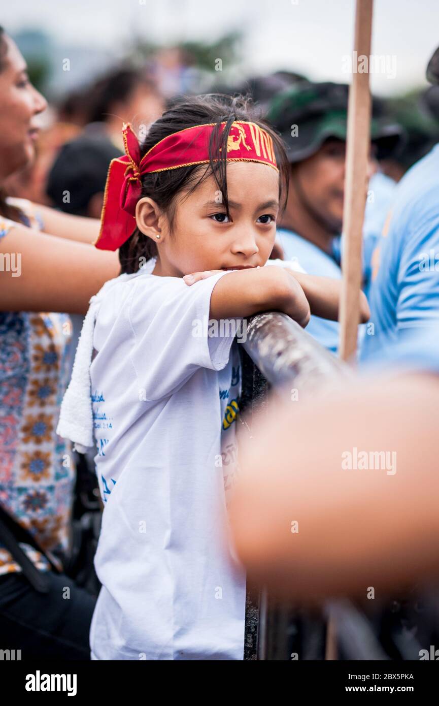 A beautiful Filipino girl watches the religious parade and celebrations at The Black Nazarene Festival in Manila, Philippines. Stock Photo