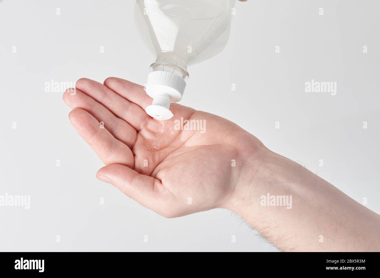 Pouring antibacterial gel on hand isolated in white background Stock Photo