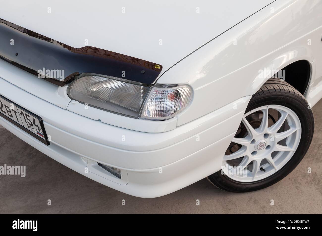 Novosibirsk, Russia - 05.20.2020: A close-up of the hood of a Lada car, wheels with a summer tire and a white disc, and a square headlamp model 2114 o Stock Photo