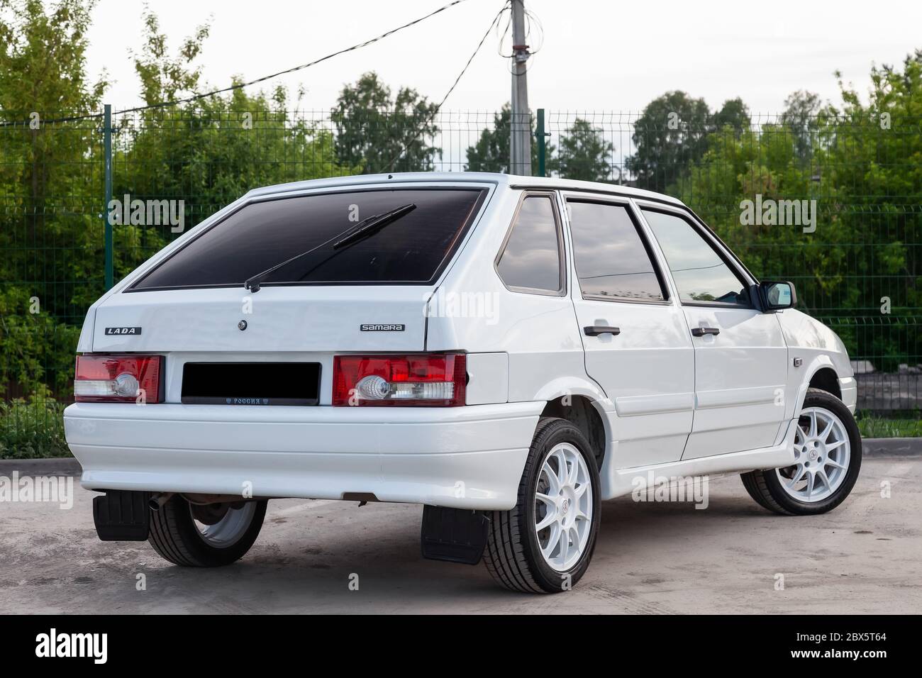 Novosibirsk, Russia - 05.20.2020: Rear view of a new Russian white car brand VAZ model 2114 with red brake lights in good condition on a summer day ag Stock Photo