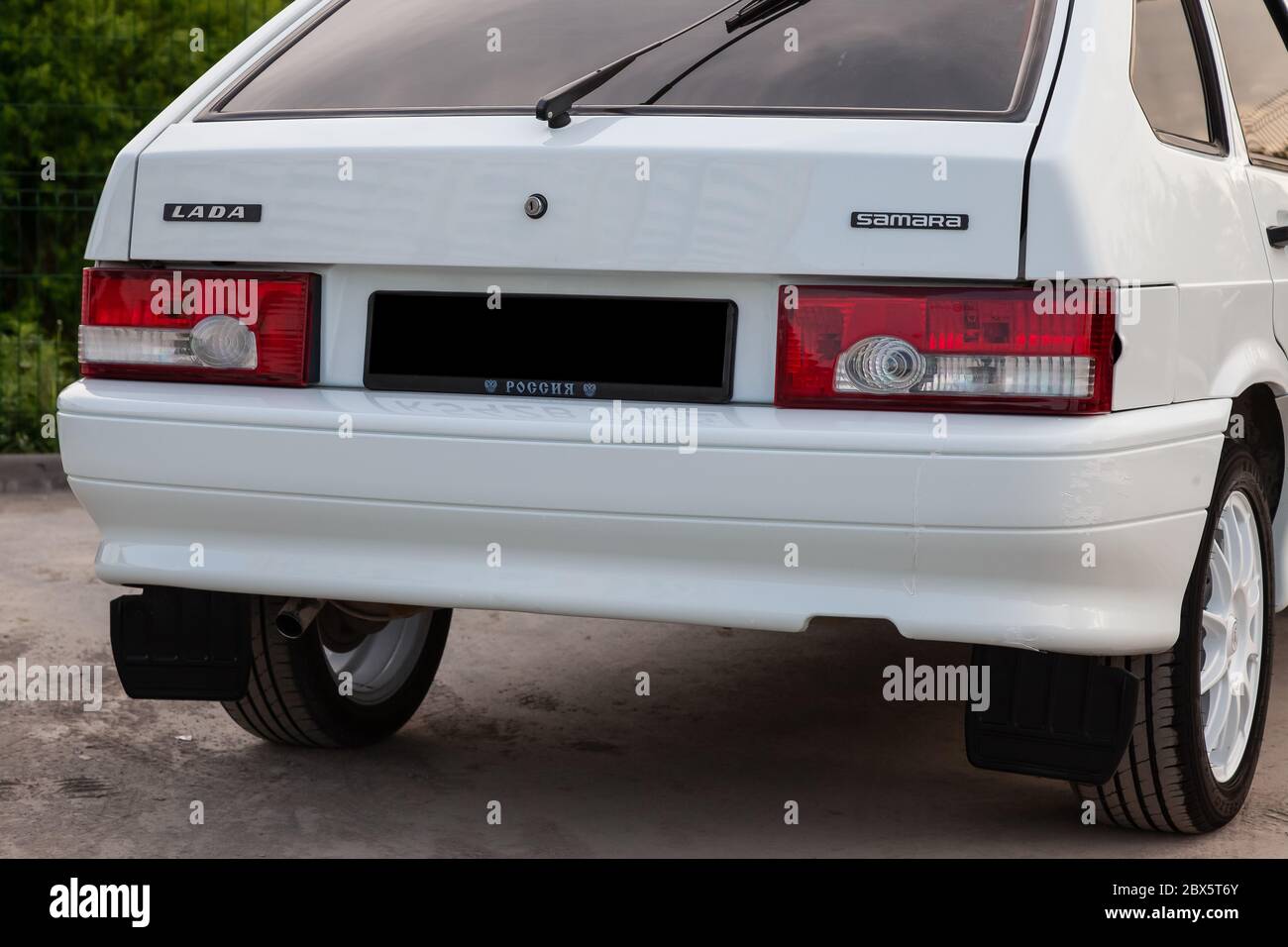 Novosibirsk, Russia - 05.20.2020: Close-up of the bumper of a Russian car of the VAZ model 2114 in white with a rear tinted glass and red brake lights Stock Photo
