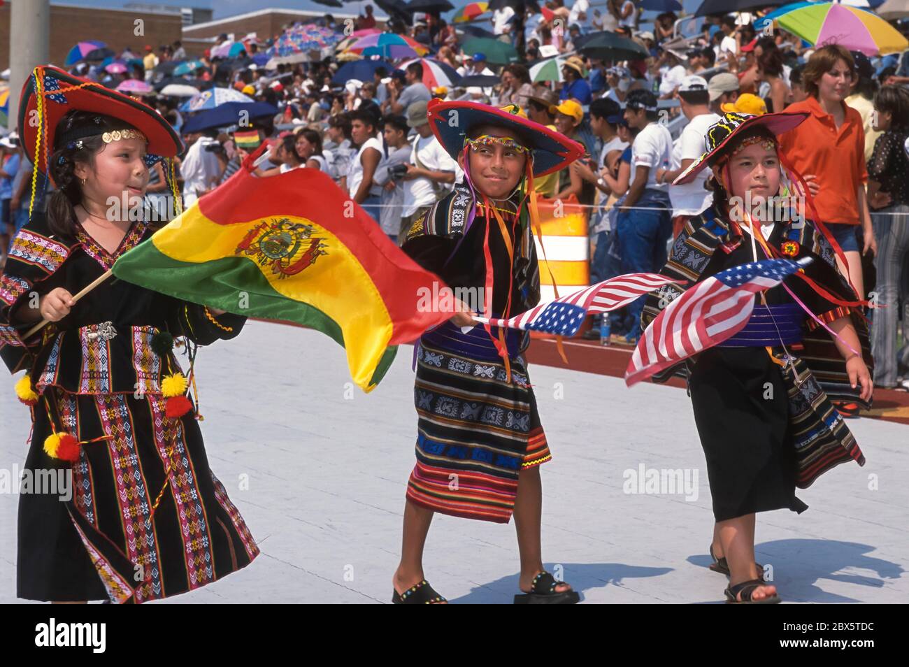 FALLS CHURCH, VIRGINIA, USA, AUGUST 2002 - Young Bolivian girls in costume dancing with flags during Bolivian Folklore festival parade. Stock Photo