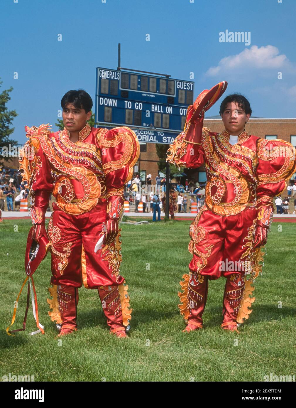 ARLINGTON, VIRGINIA, USA, AUGUST 2002 - Young Bolivian men in costume during Bolivian Folklore festival, in front of high school football scoreboard. Stock Photo