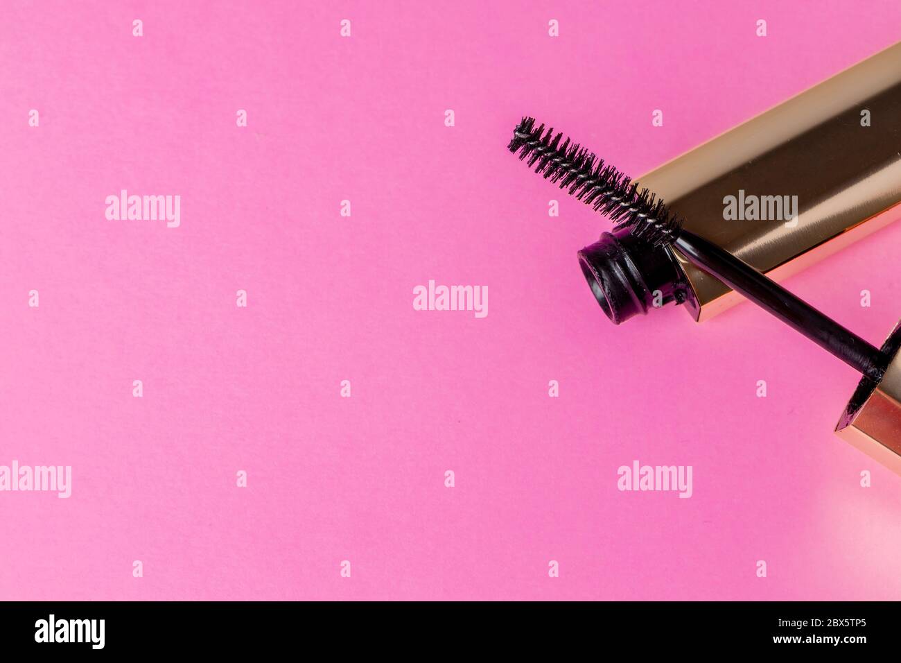 Gold tube of mascara close up on pink background Stock Photo Alamy
