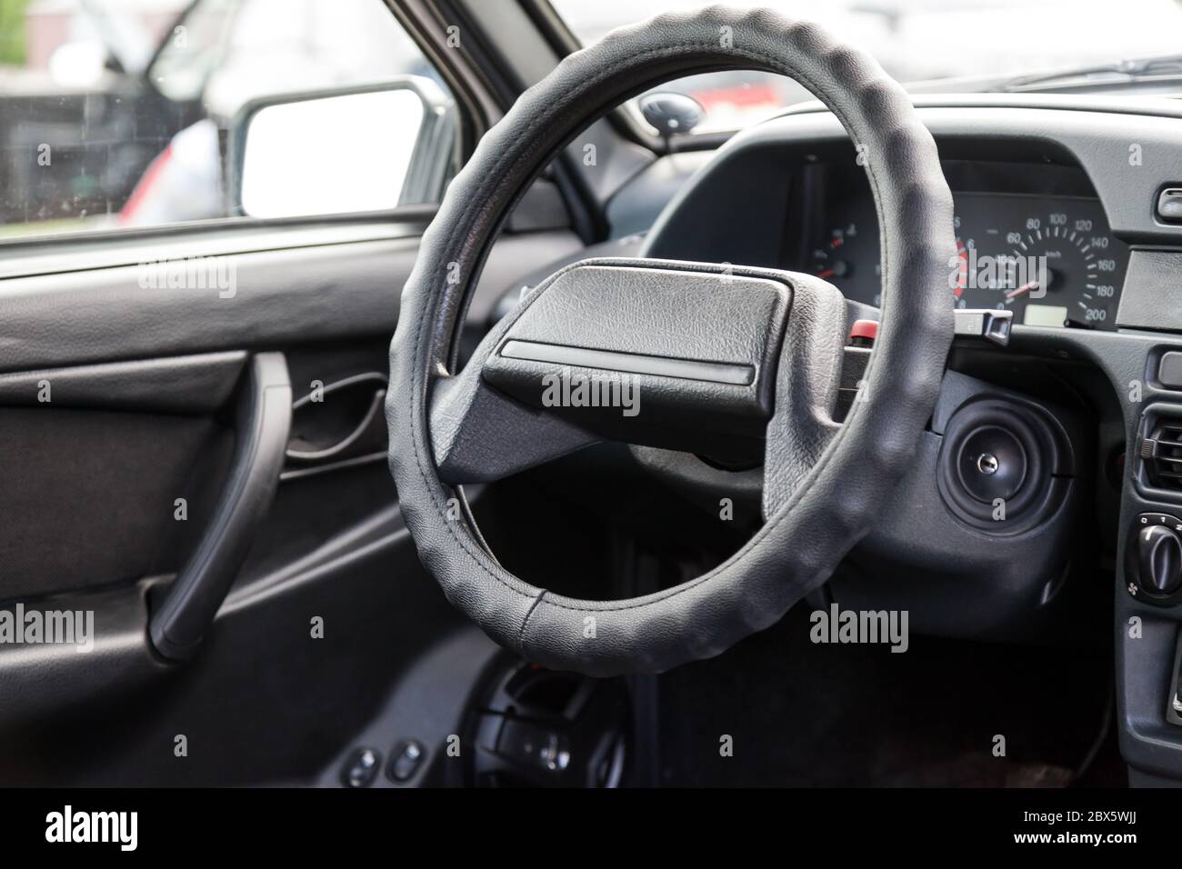 A closeup of the steering wheel of a Russian old car on a black
