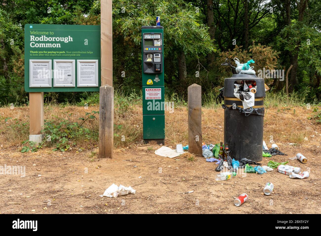 Rubbish overflowing from litter bin at a nature reserve UK. Antisocial behaviour in the countryside during the 2020 coronavirus covid-19 pandemic Stock Photo