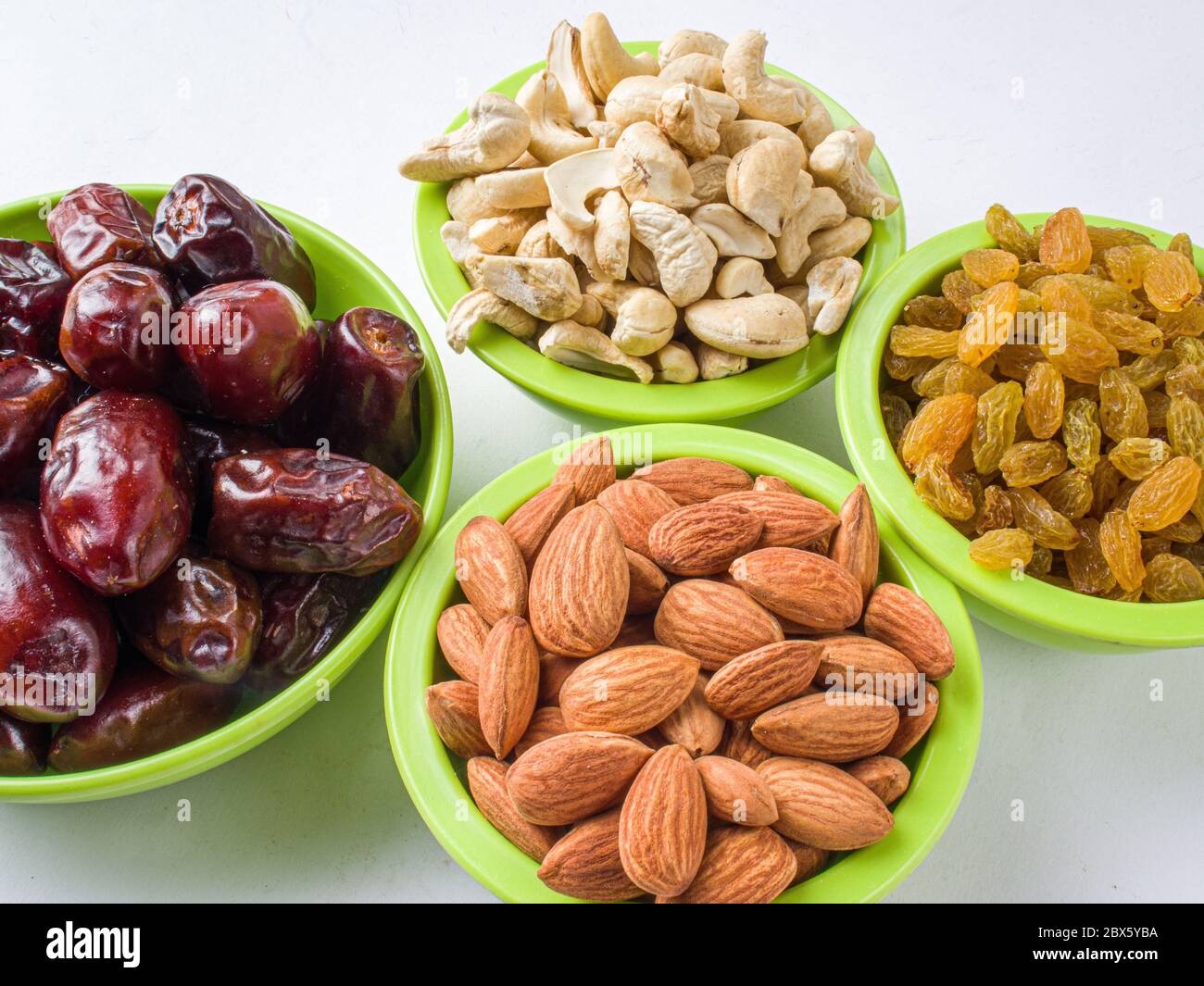 khajur, raisin/kismis, kaju badam/ cashew and almonds all at a single frame stock image white background. Stock Photo