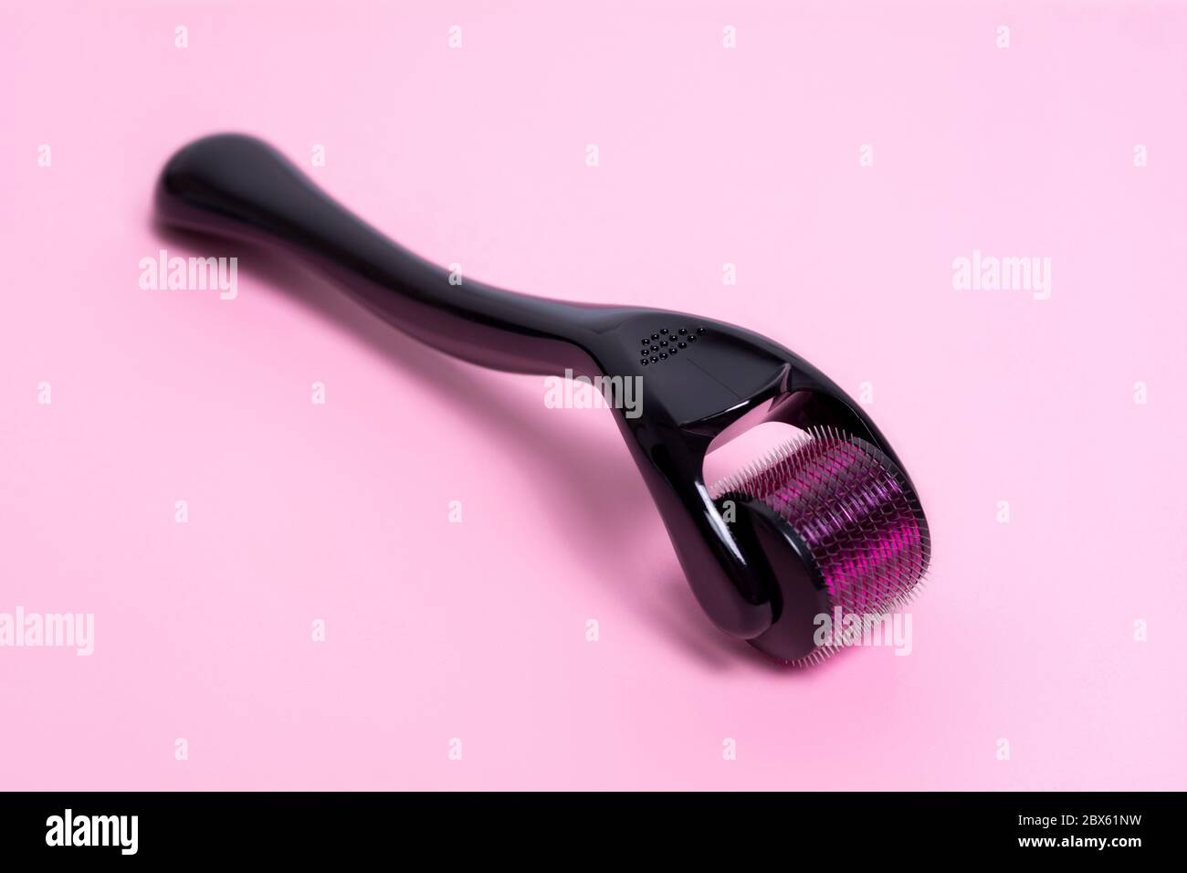 Derma roller on a pink background. The device for cosmetic procedures of mesotherapy. Stock Photo