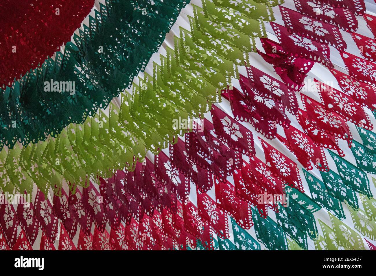 paper folded and cut into colorful patterns and used to decorate a ceiling in typical Mexican colors and style Stock Photo