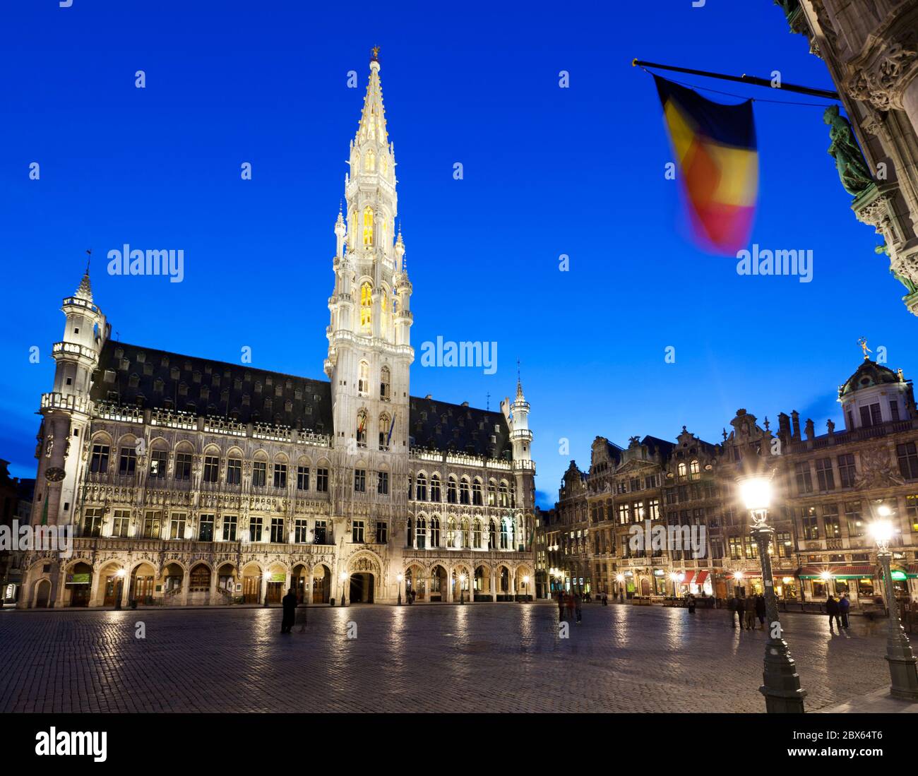 Hotel de Ville and guildhouses in the Grand Place (main Square) at dusk ...