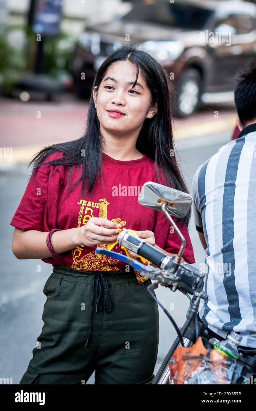 A beautiful filipino girl checks her hair before heading out on the famous annual Black Nazarene Religious Parade in Manila The Philippines. Stock Photo