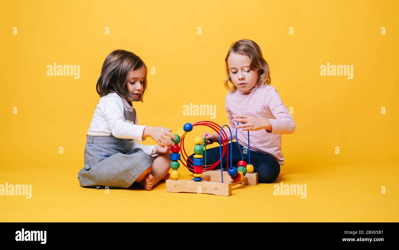 Two little girls play with toys Stock Photo - Alamy