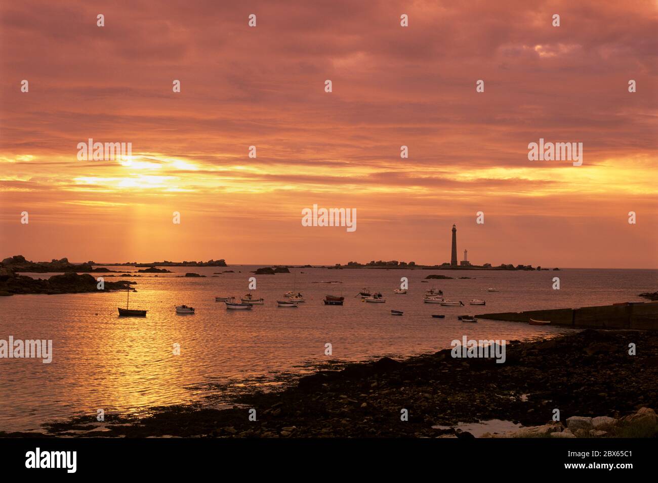 Boats and the Phare de la Vierge at sunset, Plouguerneau, Finistere, Brittany, France Stock Photo