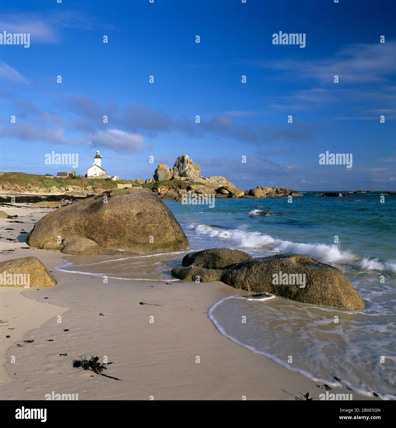 View along beach and rocks to Pointe de Pontusval Lighthouse, Brignogan Plage, Finistere, Brittany, France Stock Photo