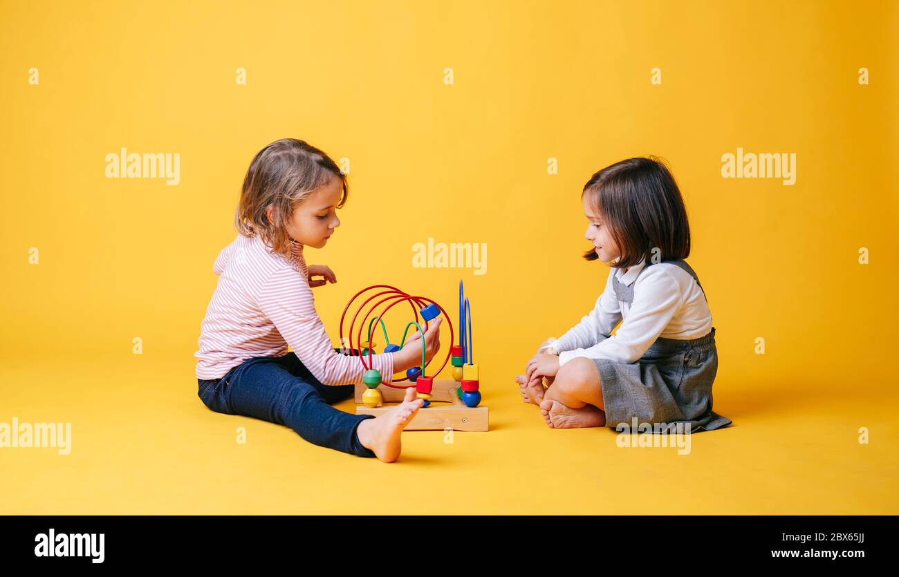 Two little girls play with toys Stock Photo - Alamy