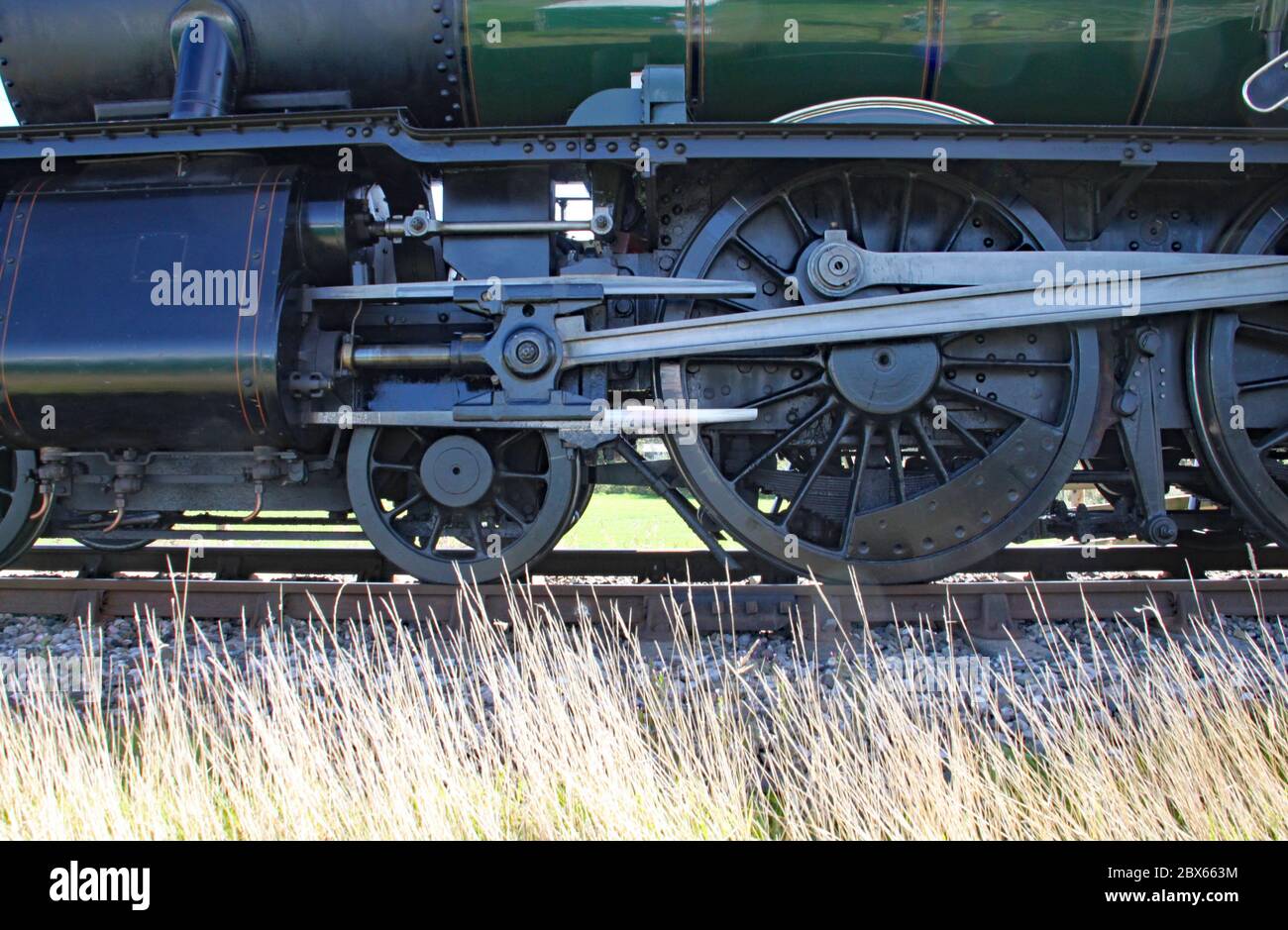 Closeup of wheels and con rods of renovated steam engine in England