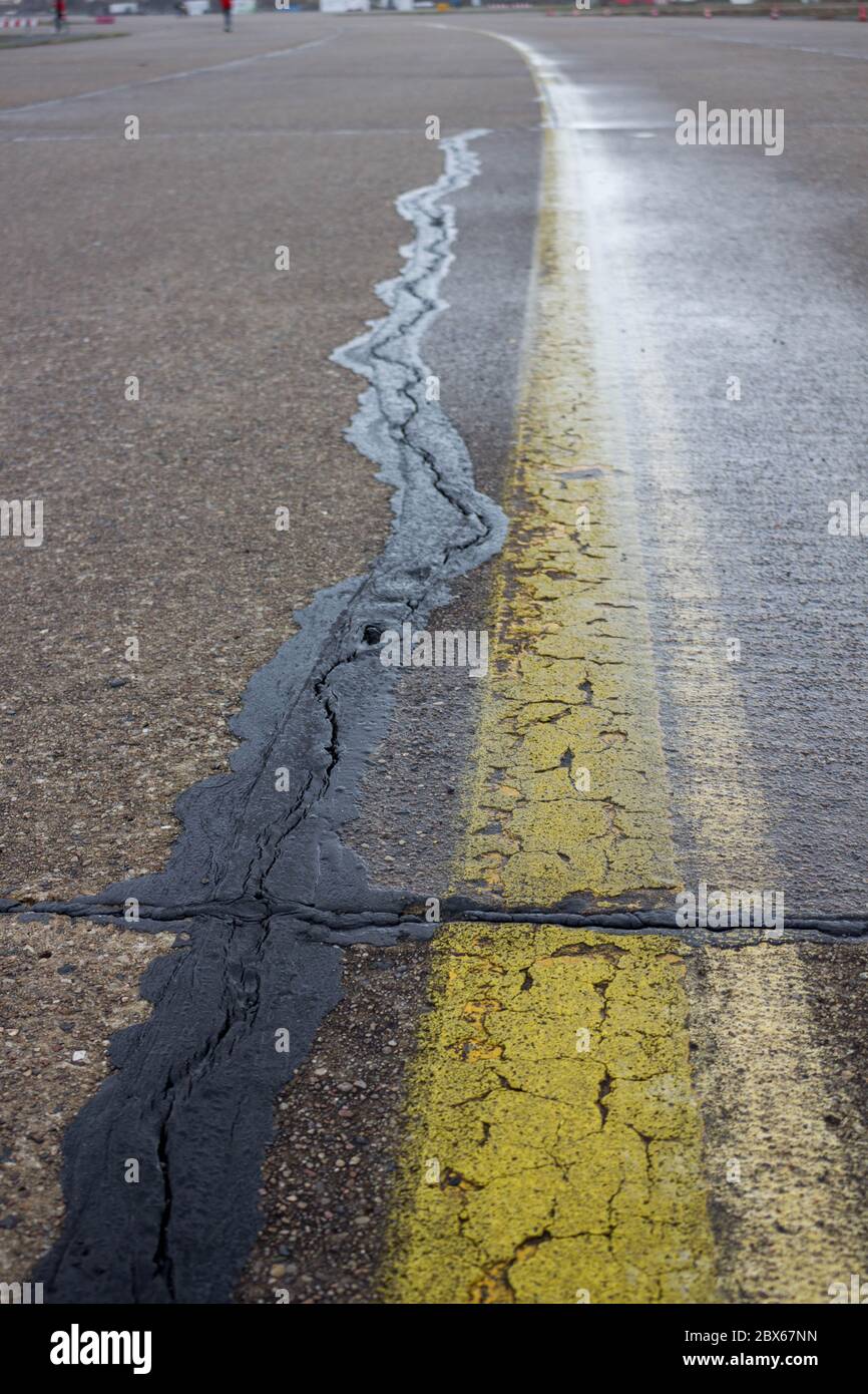 Yellow road marking and black street repair on asphalt of tempelhofer