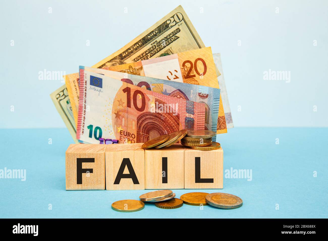 Fail word written on wood cubes on the background of various banknotes. Financial concept Stock Photo
