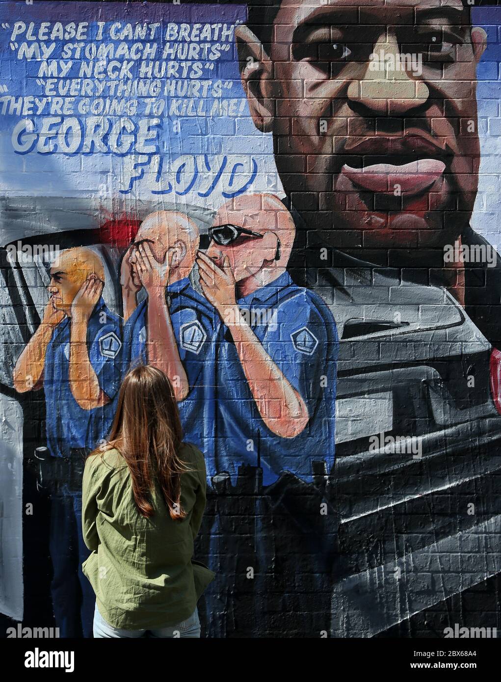 NOTE GRAPHIC CONTENT ON MURAL A woman stops to look at a mural to George Floyd at Belfast's International Wall on the Falls Road. Mr Floyd was killed on May 25 while in police custody in the US city of Minneapolis. The mural was commissioned by Feile an Phobail and Failte Feirste Thiar, and painted by Marty Lyons and Micky Doherty. Stock Photo