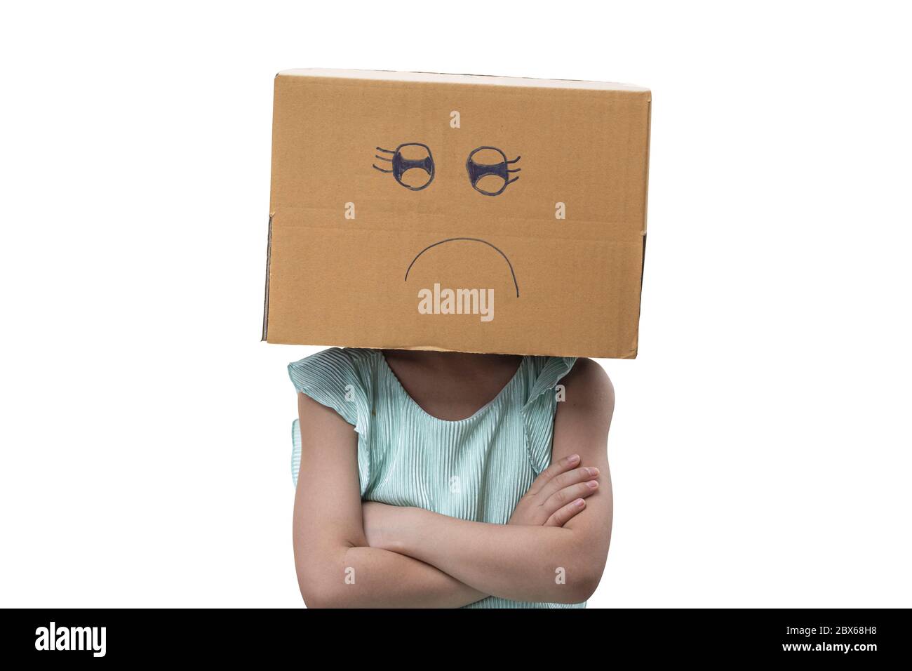 Little girl wearing cardboard box on his head with unglücklich, Isolated on white background. Stock Photo