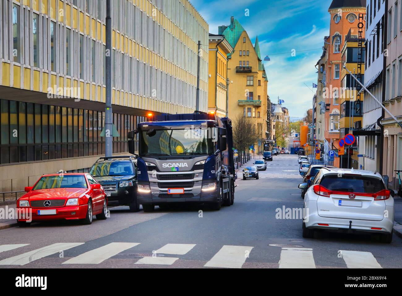 Scania P370 refuse collector truck of Lassila & Tikanoja at work on city street on a spring morning. Helsinki, Finland. May 21, 2020. Stock Photo