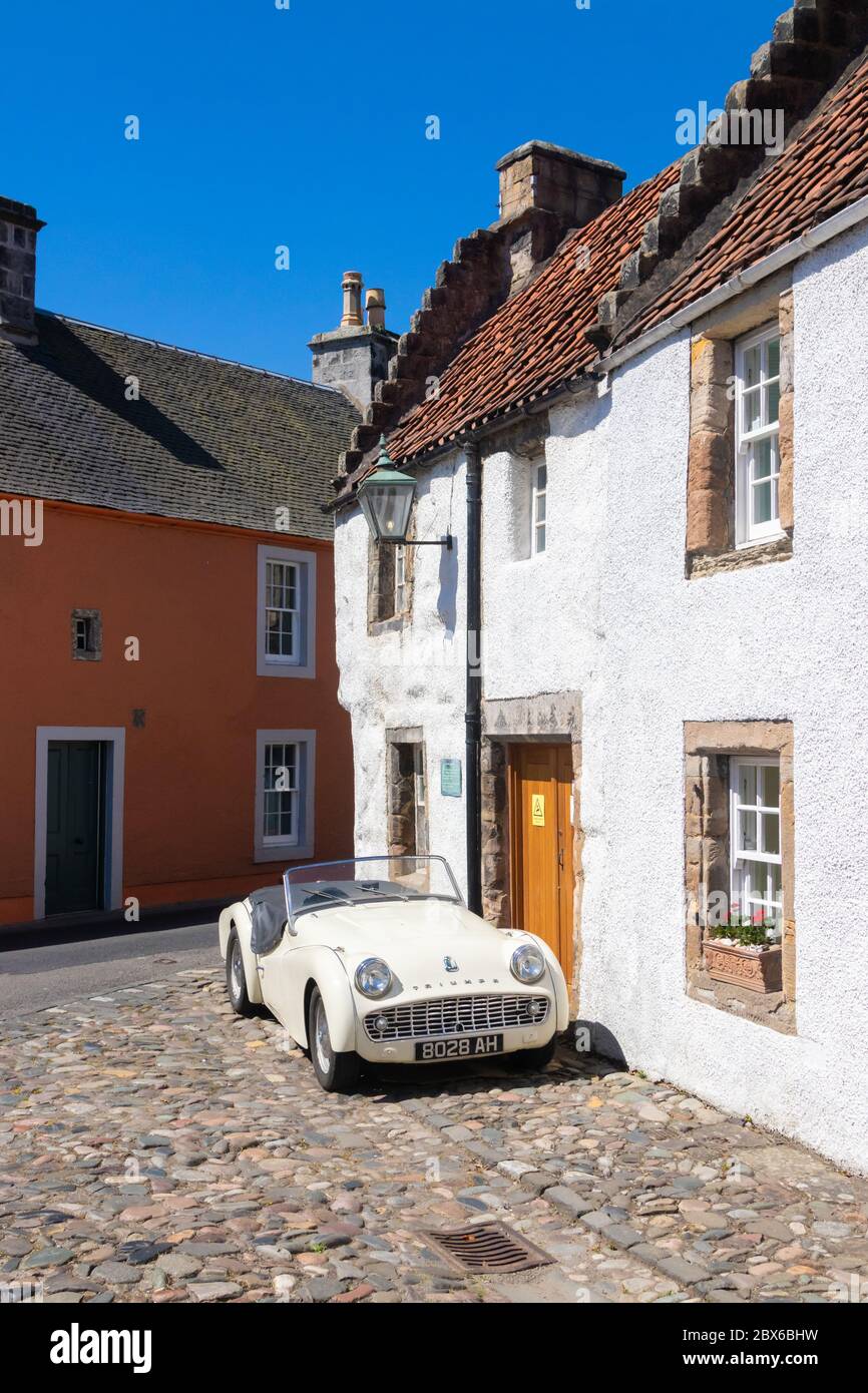 A 1959 Triumph TR3A sports car outside a traditional old house in the beautiful village of Culross, Fife, Scotland. Stock Photo