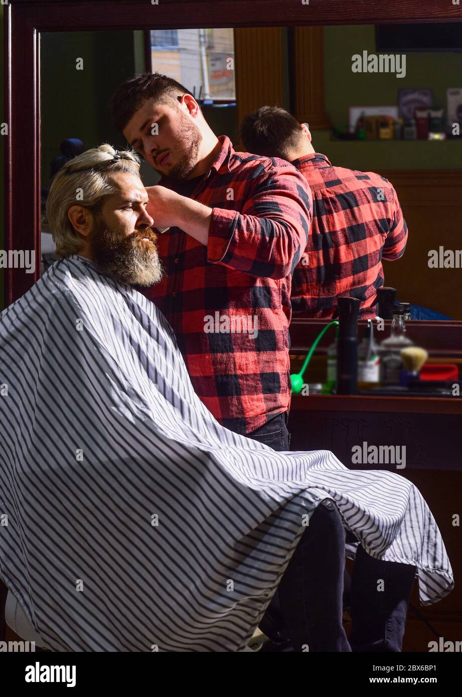 Sharp object near face and squirming distracts person holding it. Donate hair. Donation and charity concept. Guy with dyed blond hair. Cut hair. Barber hairstyle barbershop. Hipster getting haircut Stock Photo - Sharp object near face and squirming distracts person holding it. Donate hair. Donation and charity concept. Guy with dyed blond hair. Cut hair. Barber hairstyle barbershop. Hipster getting haircut Stock Photo -