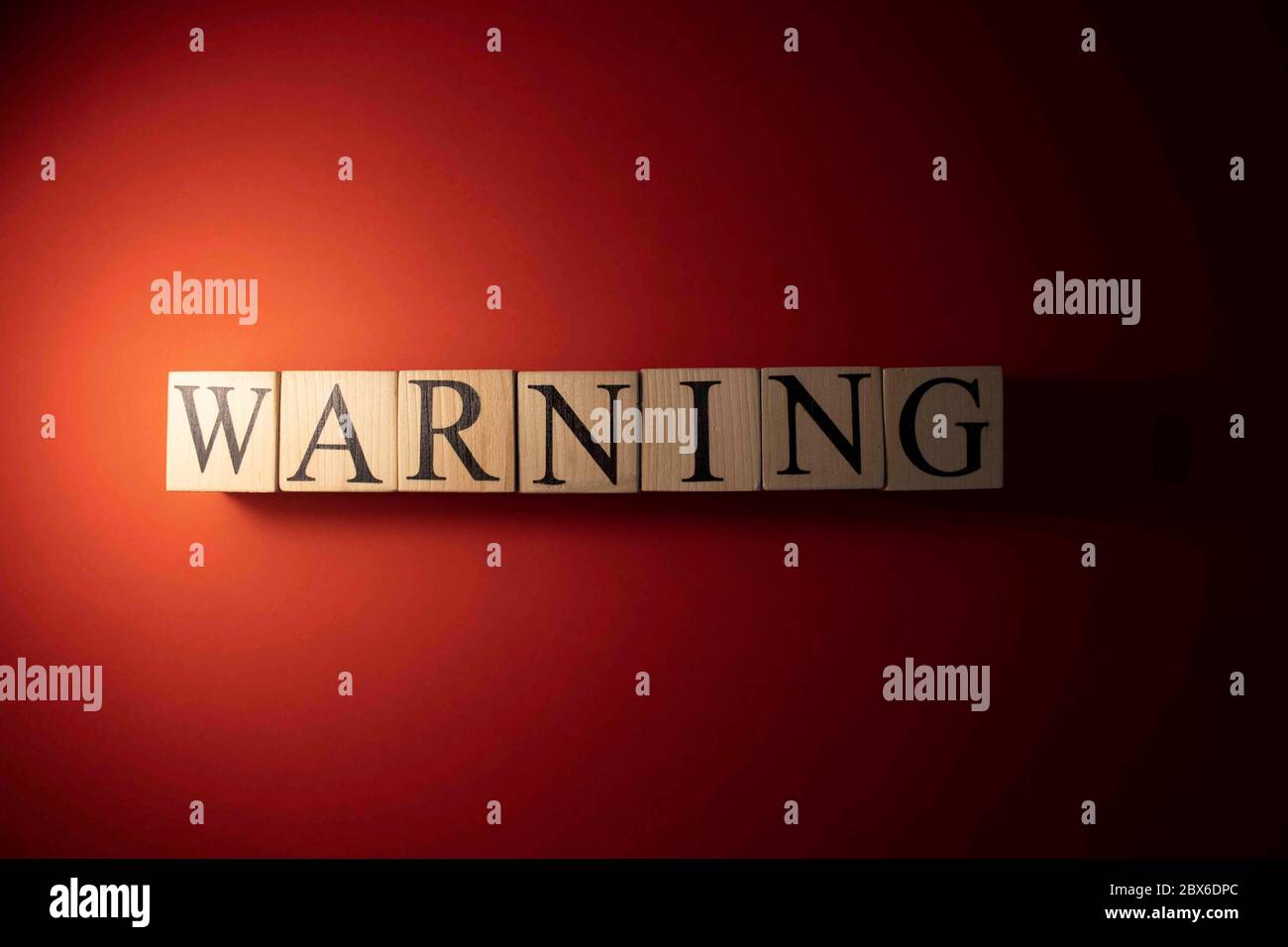 The word warning is written from wooden cubes Stock Photo Alamy
