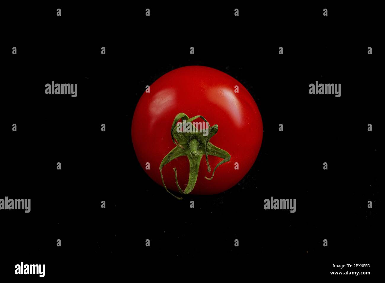 closeup of a red tomato isolated on a black studio background Stock ...