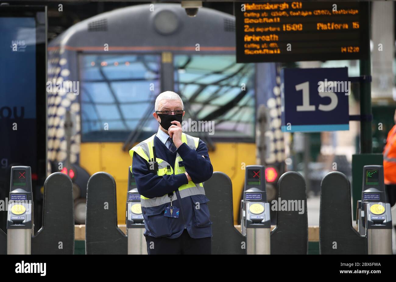 A customer service assistant at Edinburgh Waverley Station as Scotland moves into phase one of the Scottish Government's plan for gradually lifting lockdown. Stock Photo