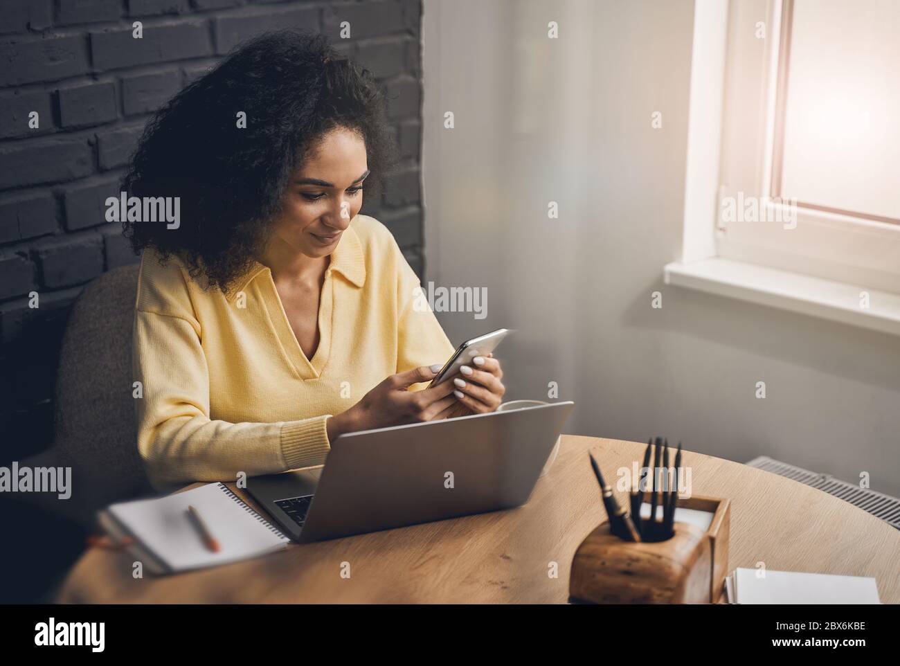 Smiling young lady sitting at the desk Stock Photo